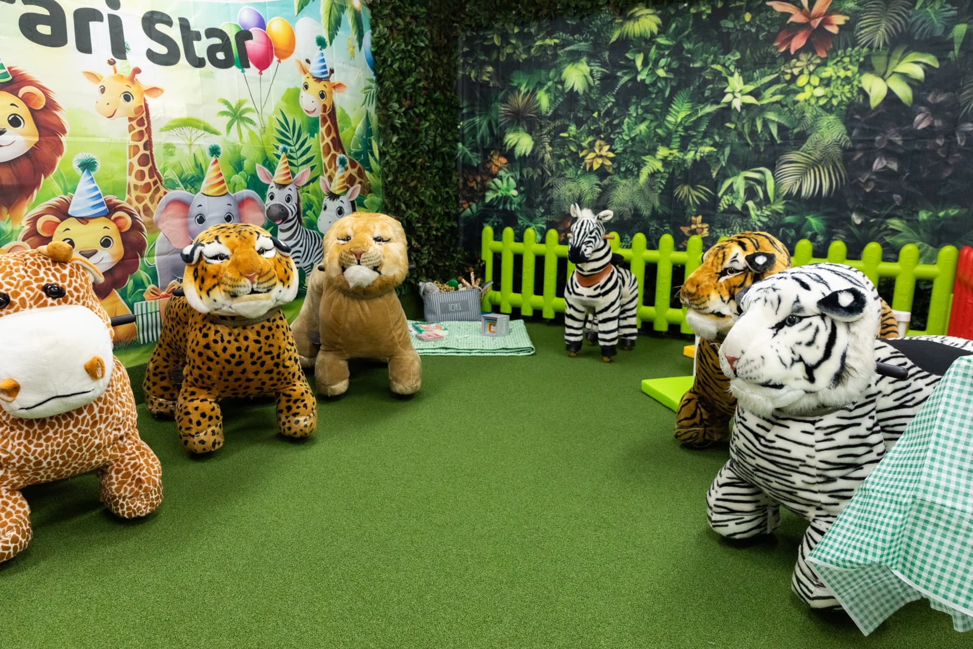 Safari animal rides on the green turf inside the Jungle Room